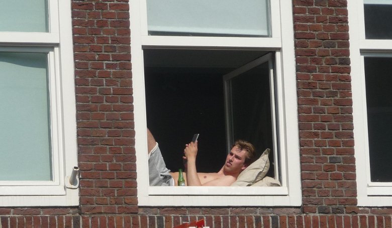 Студент в окне в Амстердаме
